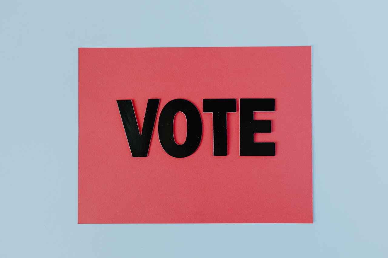 Black letters spelling VOTE on red paper, emphasizing political participation.